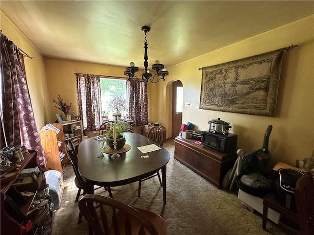 dining area featuring carpet flooring and an inviting chandelier