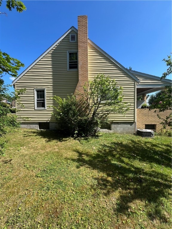 view of property exterior featuring cooling unit and a yard