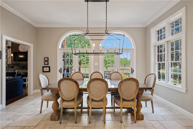 dining area with a notable chandelier, crown molding, and a wealth of natural light