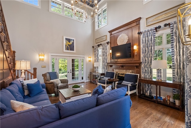 living room featuring a wealth of natural light, french doors, hardwood / wood-style flooring, and a towering ceiling