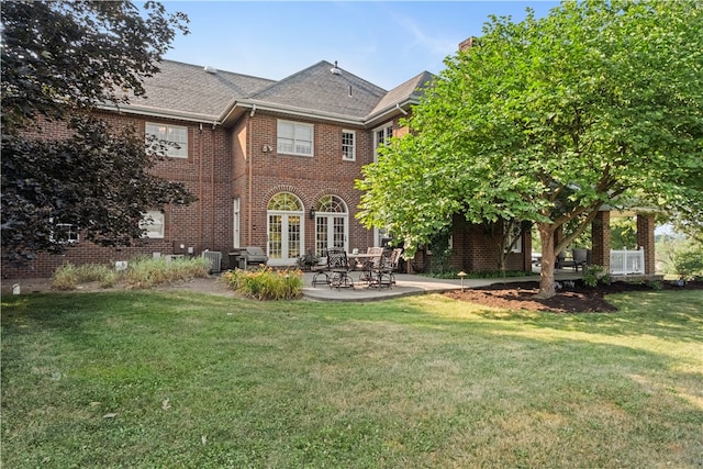 rear view of property featuring a patio and a lawn