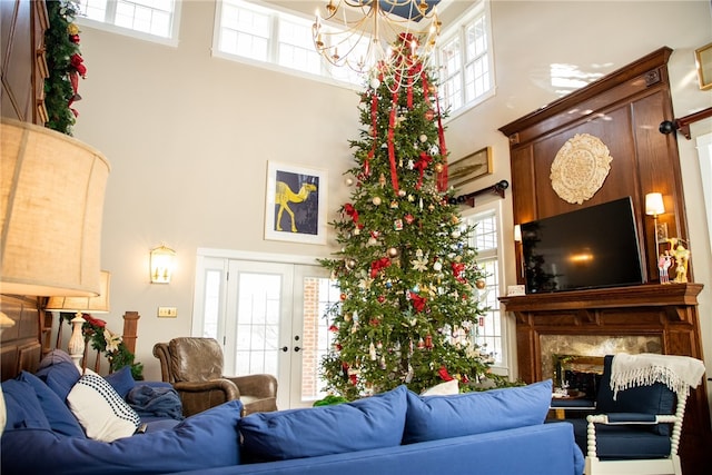 living room with a healthy amount of sunlight, a high end fireplace, and a towering ceiling