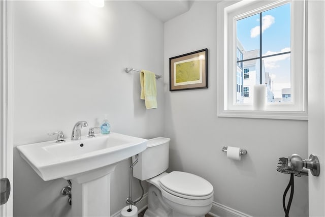 bathroom with toilet and a wealth of natural light