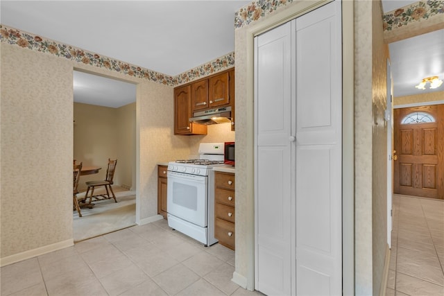 kitchen with light tile patterned flooring and gas range gas stove