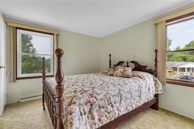 bedroom featuring baseboard heating and light colored carpet