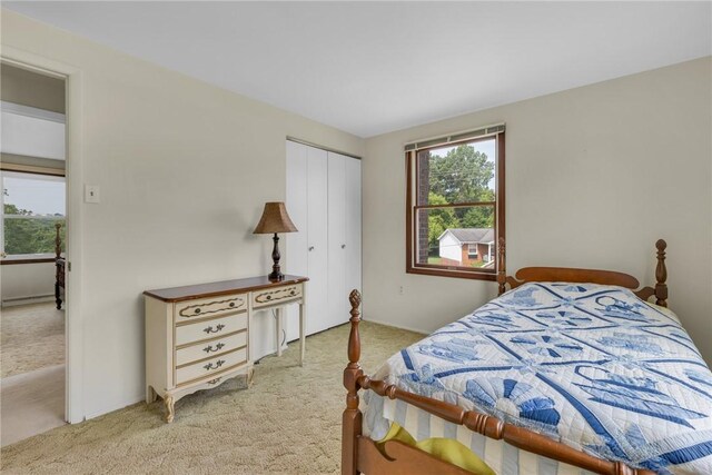 bedroom with light colored carpet and a closet