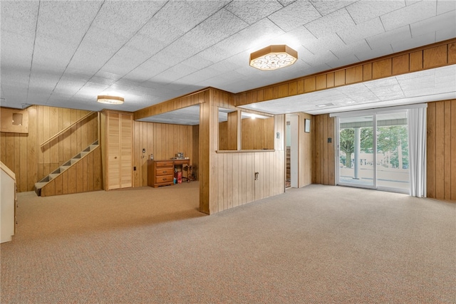 basement featuring carpet and wooden walls