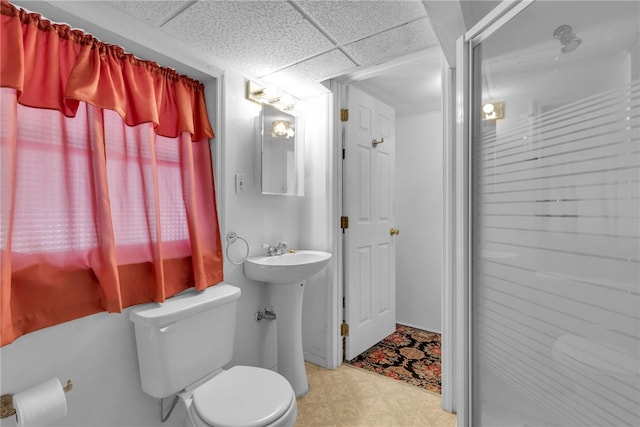 bathroom featuring tile patterned flooring, toilet, and a paneled ceiling