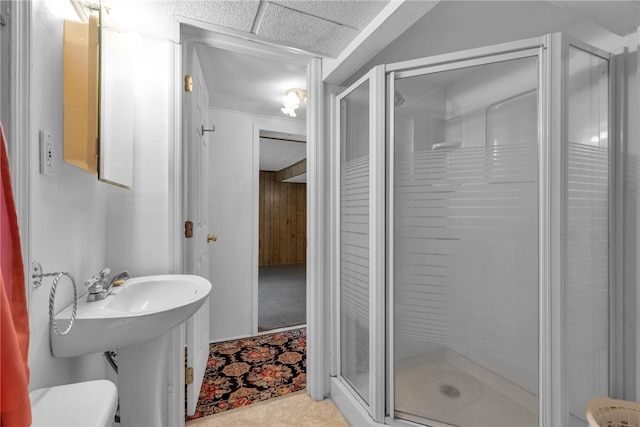 bathroom with a shower with shower door, tile patterned flooring, and toilet