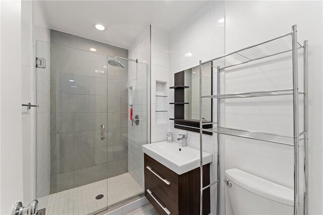 bathroom with vanity, walk in shower, and toilet