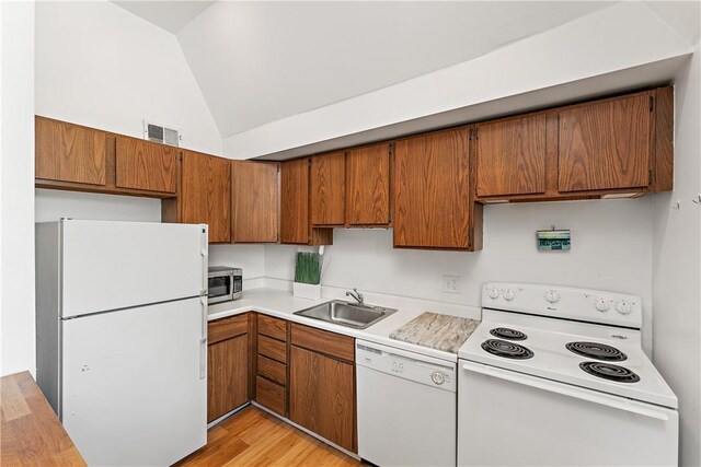 kitchen featuring lofted ceiling, light hardwood / wood-style flooring, white appliances, and sink