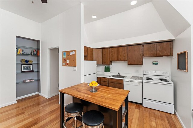 kitchen featuring light hardwood / wood-style flooring, white appliances, ceiling fan, sink, and high vaulted ceiling