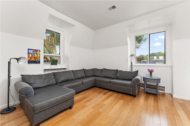 living room with a baseboard radiator and light wood-type flooring