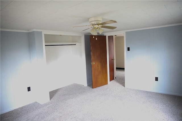 unfurnished bedroom with crown molding, light colored carpet, ceiling fan, and a closet