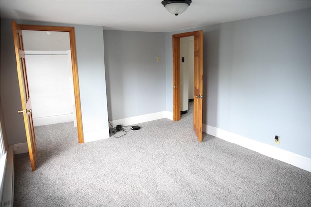 unfurnished bedroom with light colored carpet and a closet