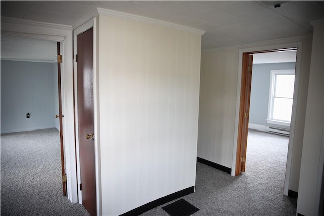 hallway featuring dark colored carpet, ornamental molding, and a baseboard radiator