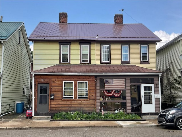 view of front of house with a chimney and metal roof