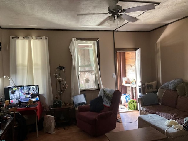 living area featuring a textured ceiling, ceiling fan, and wood finished floors