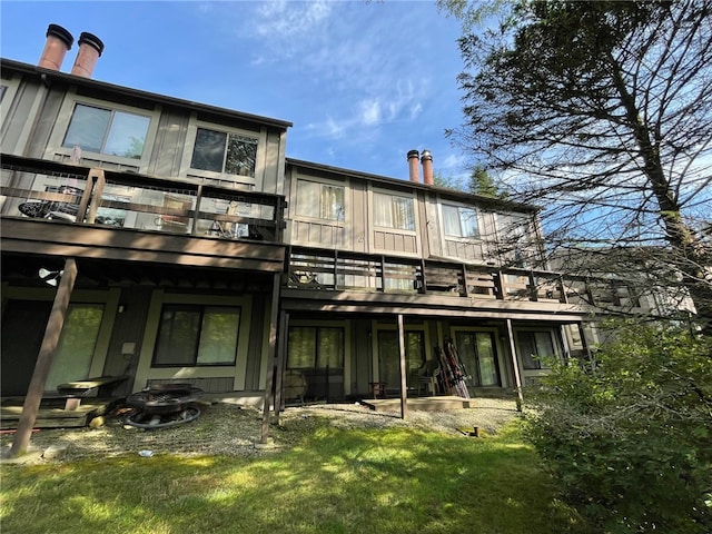 back of house featuring a patio, a balcony, and a lawn