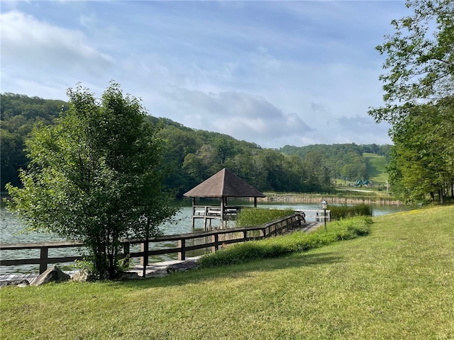 surrounding community featuring a lawn and a water view