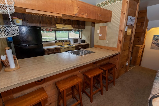 kitchen with black refrigerator, a kitchen breakfast bar, carpet flooring, electric range oven, and sink