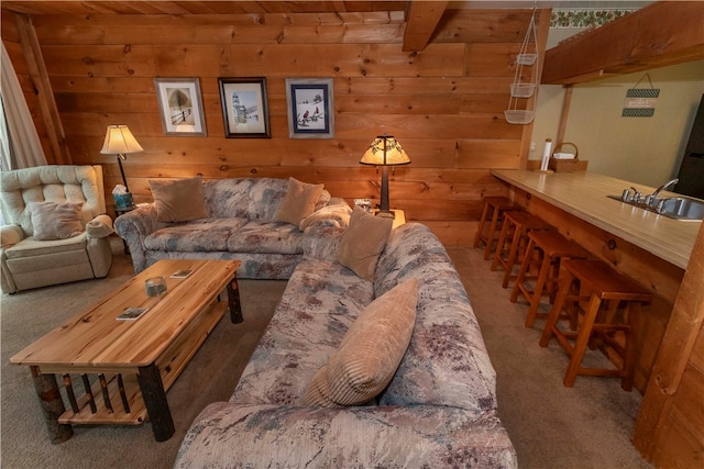 living room with beamed ceiling, carpet floors, wooden ceiling, and sink