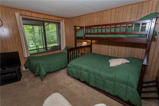 carpeted bedroom featuring wood walls