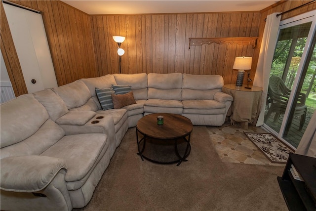 carpeted living room with wood walls