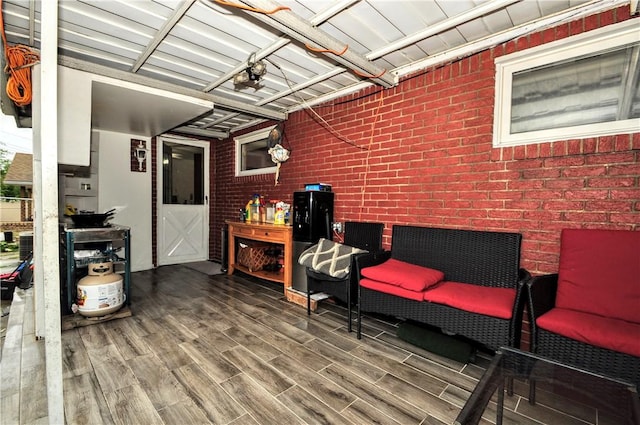 sitting room featuring hardwood / wood-style flooring and brick wall