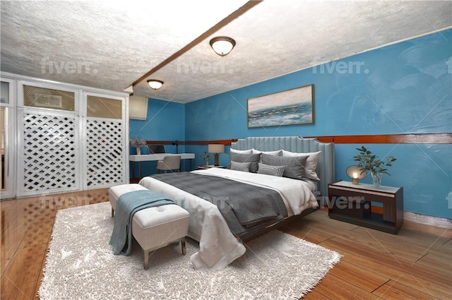 bedroom with hardwood / wood-style floors and a textured ceiling