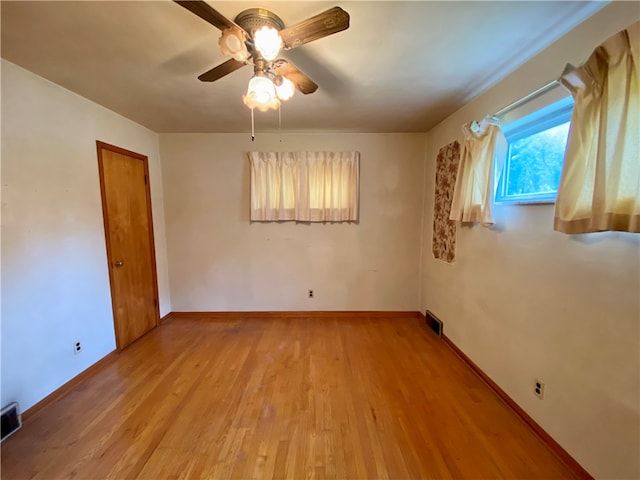 empty room with light hardwood / wood-style flooring and ceiling fan