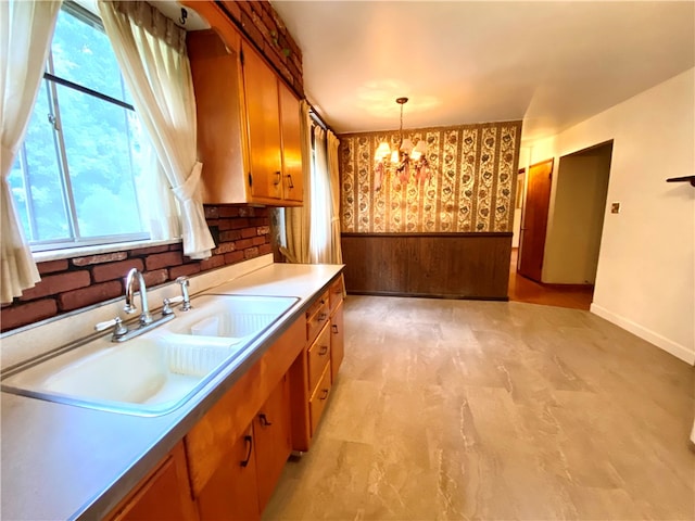 kitchen featuring sink, an inviting chandelier, a healthy amount of sunlight, and light tile patterned floors