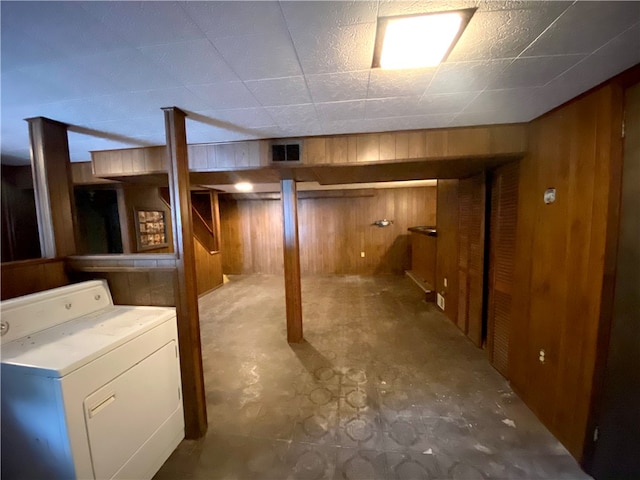 basement featuring washer / dryer and wooden walls