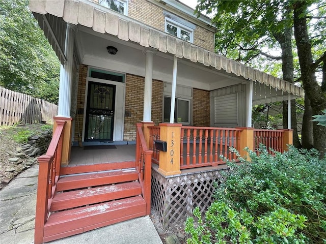 view of exterior entry featuring covered porch