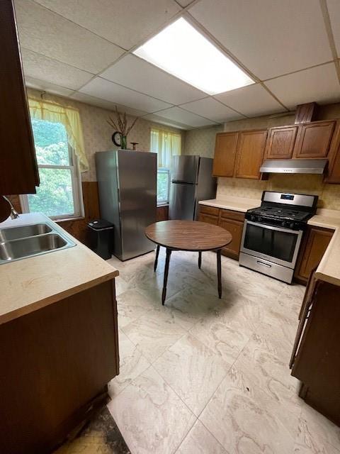 kitchen with a drop ceiling, sink, and appliances with stainless steel finishes