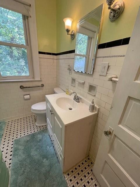 bathroom with vanity, plenty of natural light, tile walls, and toilet