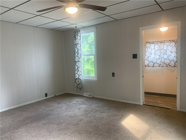 unfurnished room featuring ceiling fan, carpet flooring, and a paneled ceiling