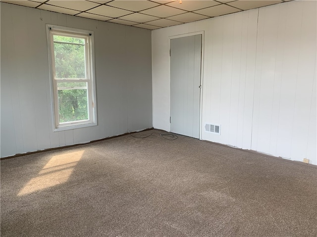 carpeted spare room with a paneled ceiling