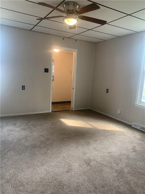 carpeted spare room featuring ceiling fan and a paneled ceiling