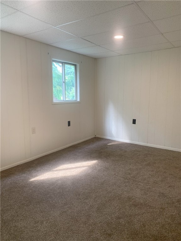 empty room with a paneled ceiling and carpet flooring