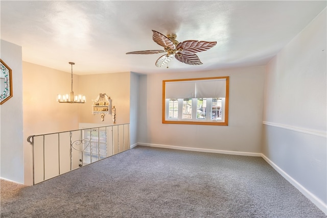 empty room with carpet and ceiling fan with notable chandelier