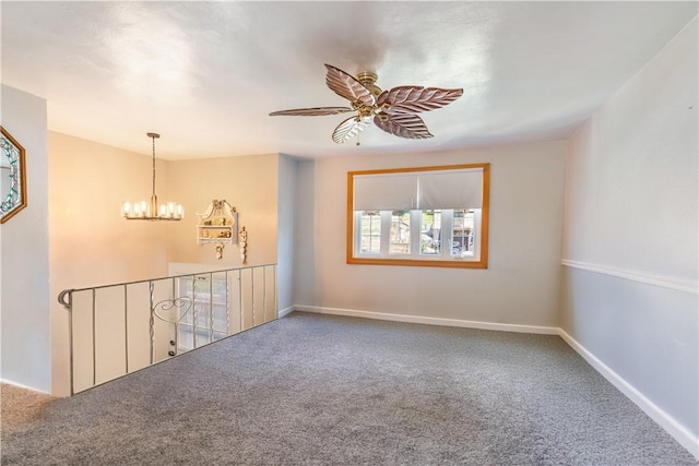 carpeted empty room with ceiling fan with notable chandelier