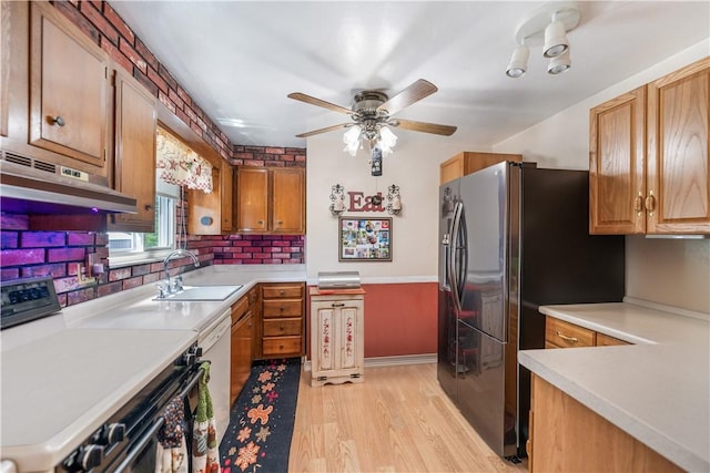 kitchen with sink, black fridge, light hardwood / wood-style flooring, dishwasher, and stove