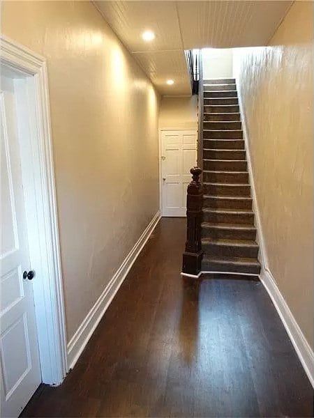 stairway featuring dark wood-type flooring