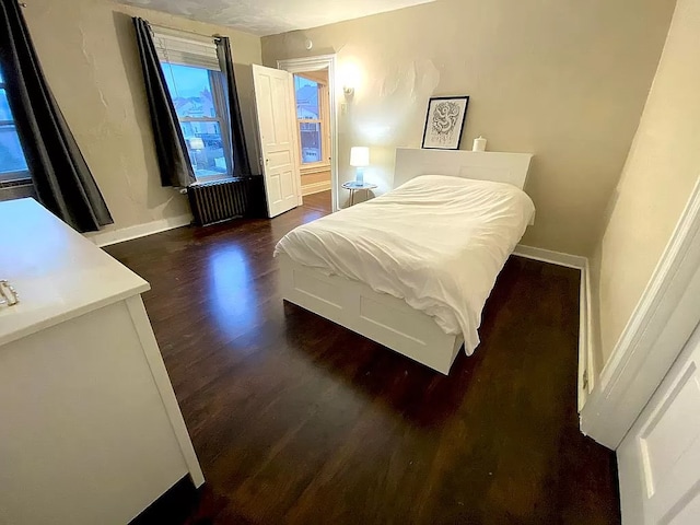 bedroom featuring hardwood / wood-style flooring and radiator heating unit