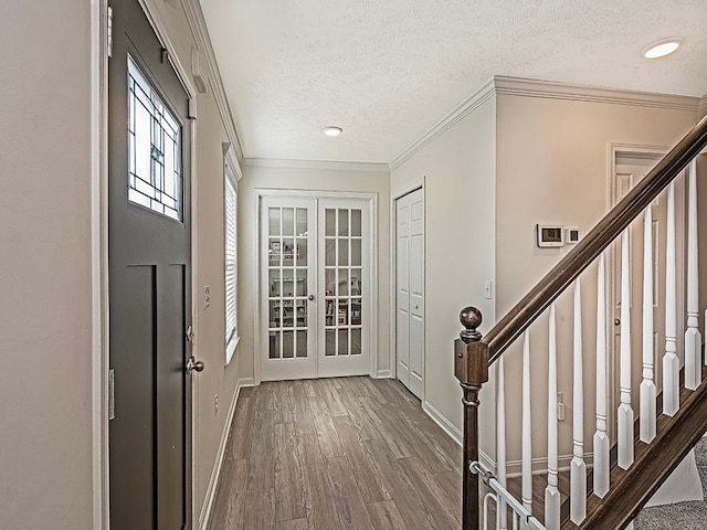 interior space featuring hardwood / wood-style flooring, a textured ceiling, french doors, and ornamental molding