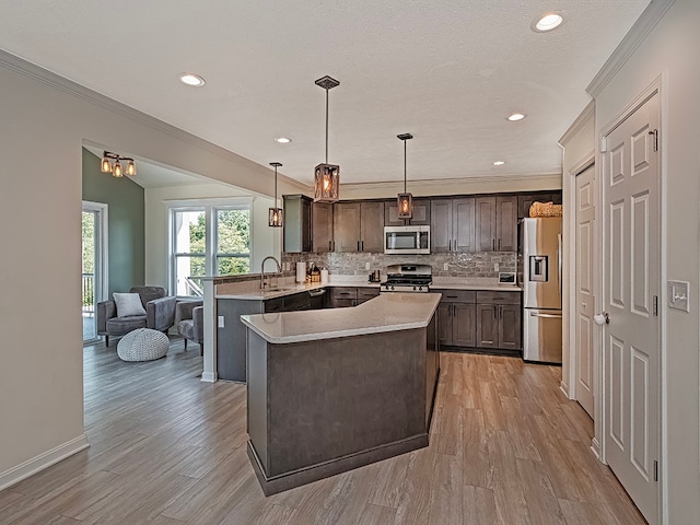 kitchen featuring light hardwood / wood-style flooring, tasteful backsplash, kitchen peninsula, appliances with stainless steel finishes, and dark brown cabinetry