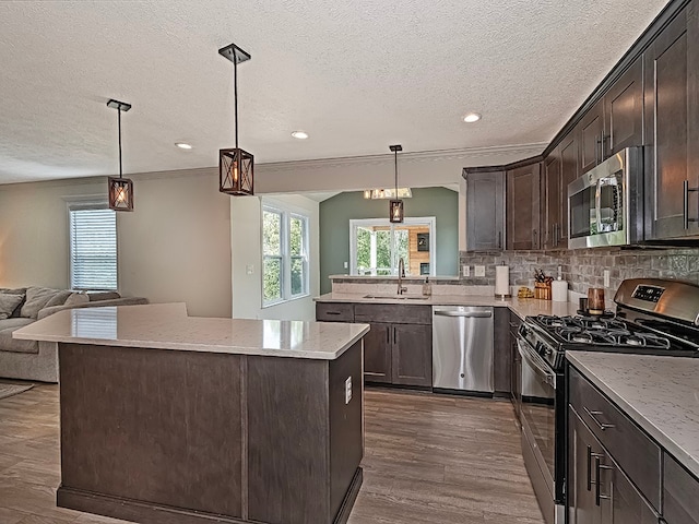 kitchen featuring appliances with stainless steel finishes, sink, dark brown cabinets, decorative backsplash, and dark wood-type flooring