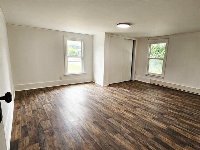 spare room with hardwood / wood-style flooring, a baseboard heating unit, and a wealth of natural light