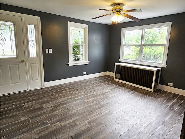 foyer featuring radiator heating unit, ceiling fan, hardwood / wood-style flooring, and a healthy amount of sunlight